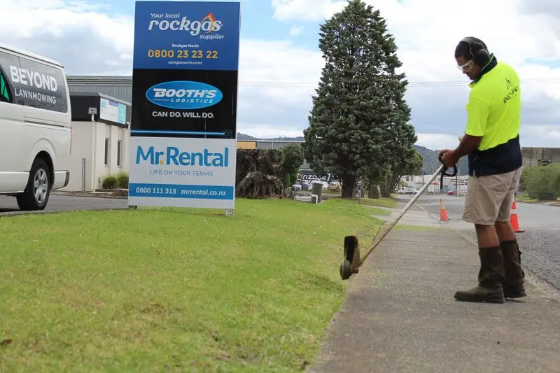 Kawana trimming grass outside a commercial site