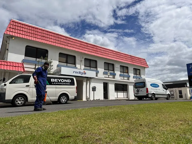 Kawana trimming the lawn outside a commercial building