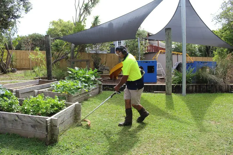 Kawana trimming around raised garden beds